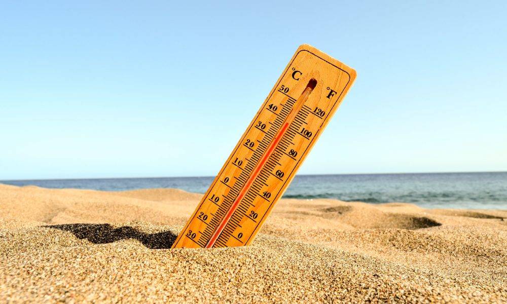 酷熱 氣候變化 A selective focus shot of a thermometer in the beach sand with a blurred background